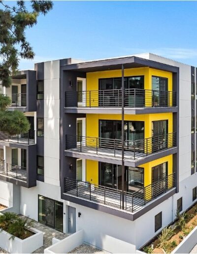 An apartment building with balconies and palm trees.